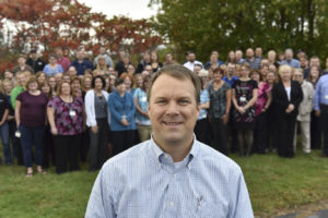 Jake Holzscheiter, President & CEO, with group of employees